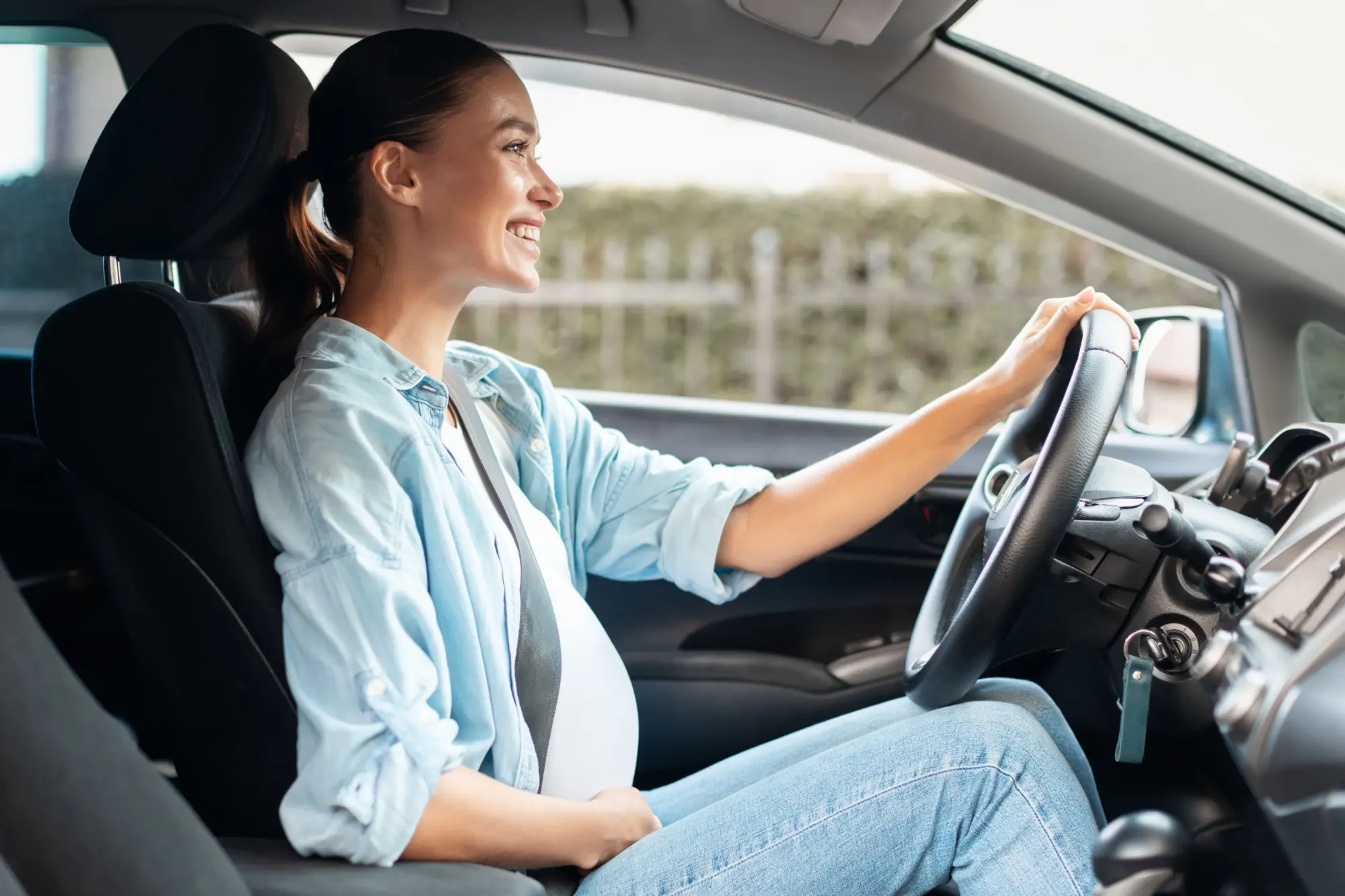 - MotorGuru.cz Mladá těhotná žena za volantem.
