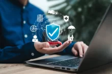 Osoba u notebooku drží virtuální štít s ikonami služeb