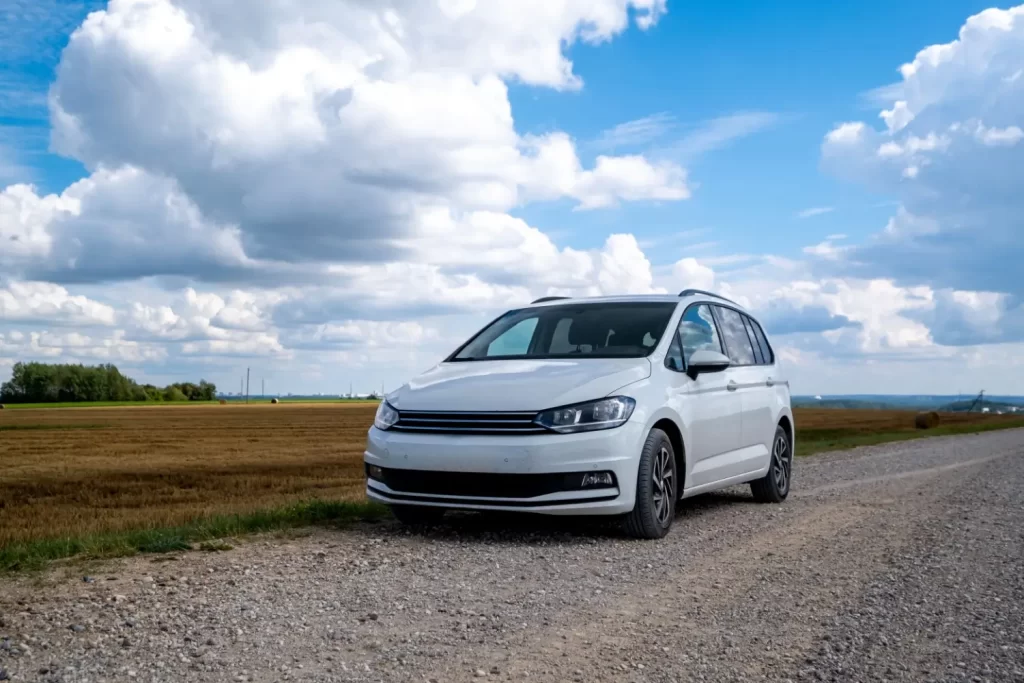 - MotorGuru.cz Bílé osobní auto zaparkované na štěrkové cestě