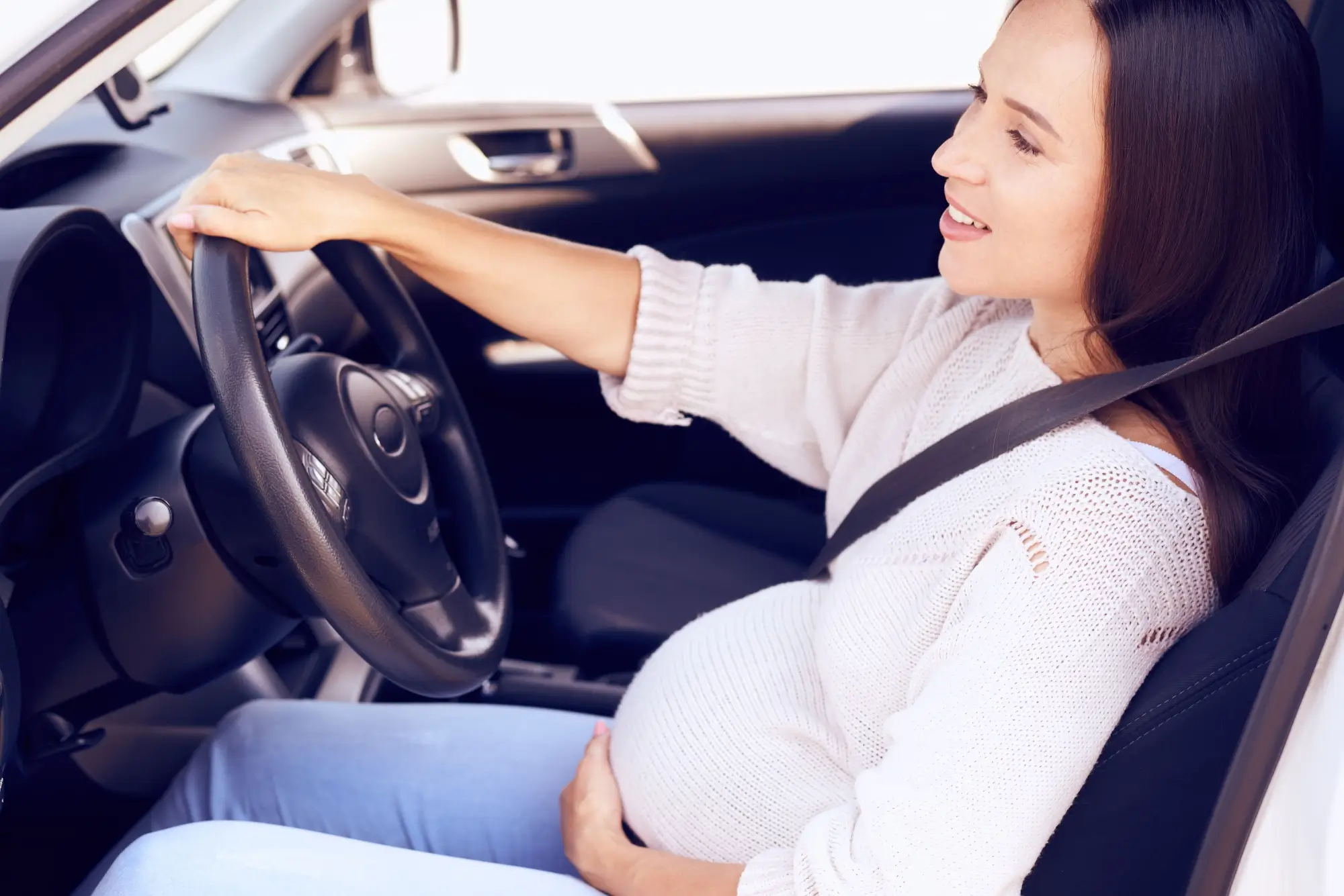 - MotorGuru.cz Mladá těhotná žena při řízení auta.