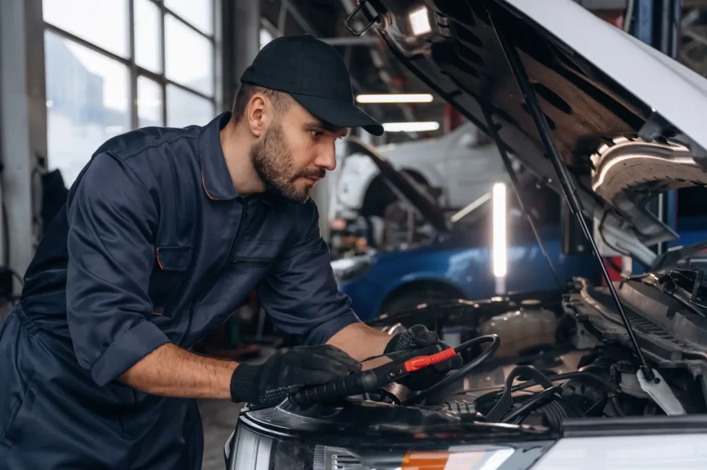 - MotorGuru.cz Automechanik se sklání nad otevřenou kapotou