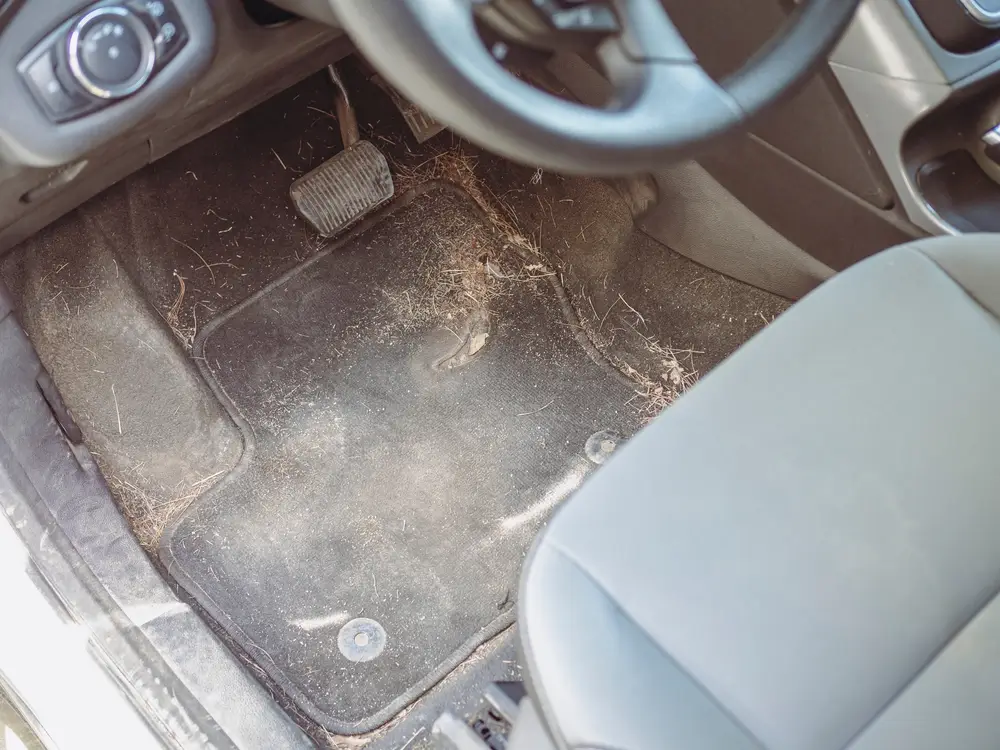 Pohled na špinavý autokoberec u řidiče