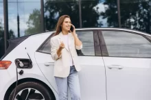 Žena čekající na nabití jejího elektromobilu.