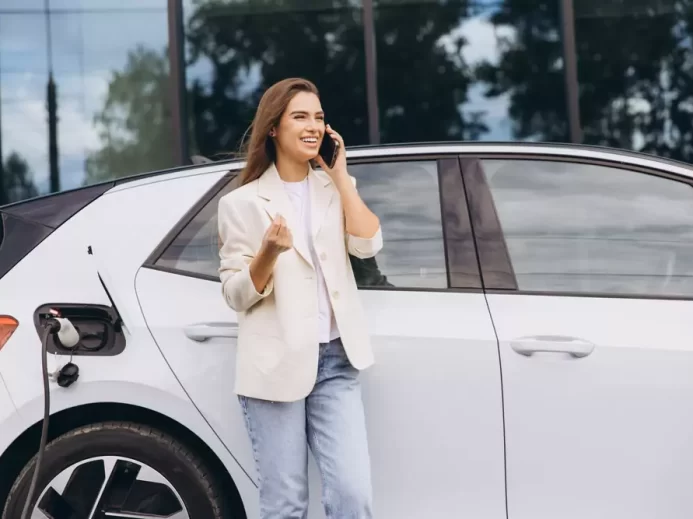 Žena čekající na nabití jejího elektromobilu.