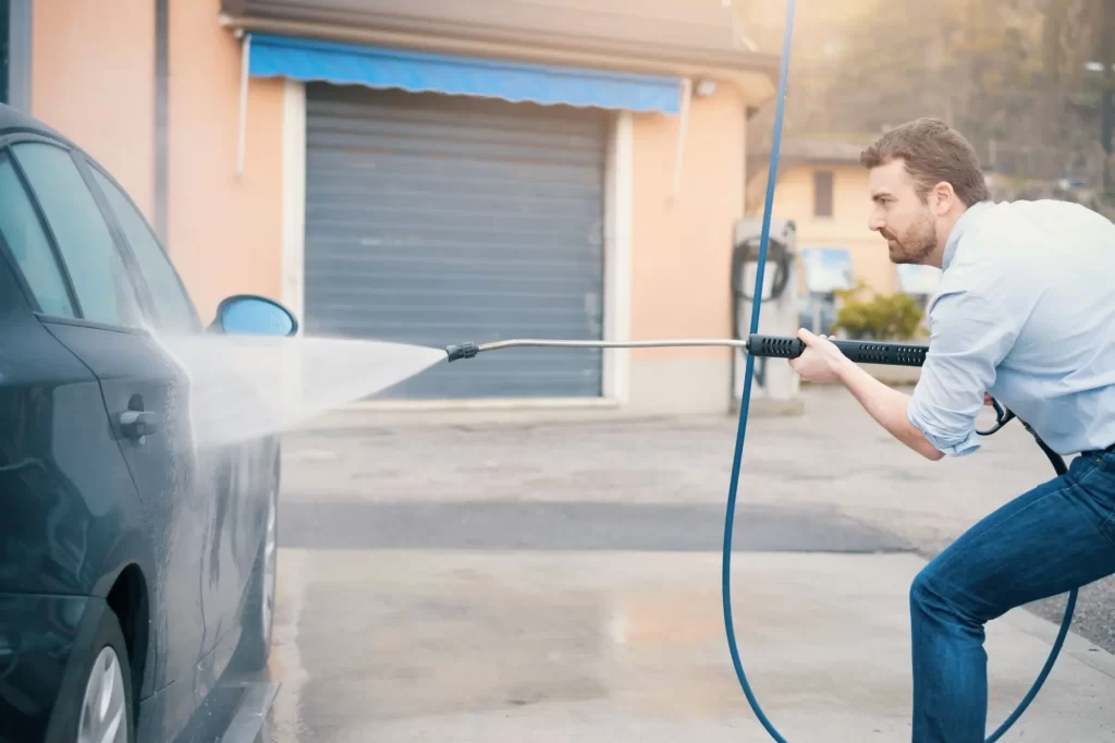 - MotorGuru.cz Muž myje auto tlakovou myčkou