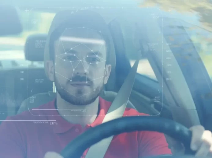 Muž za volantem vozu s aktivní detekcí obličeje pomocí biometrické technologie