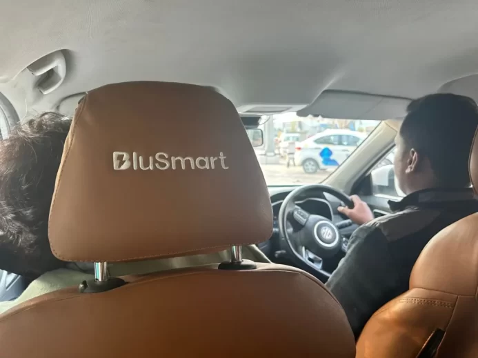 Pohled ze sedadla spolujezdce na řidiče BluSmart