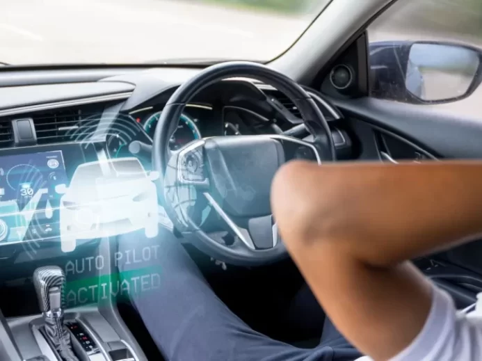 Muž jede v autonomním autě, neřídí