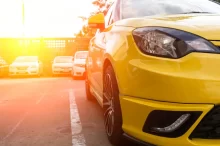 Záběr na žluté auto zaparkované na venkovním parkovišti