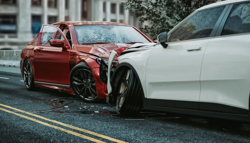 Dvě auta po čelní srážce uprostřed silnice – červený sedan a bílé SUV. 