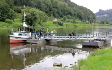 Říční loď stojí u mola, nastupují pasažéři