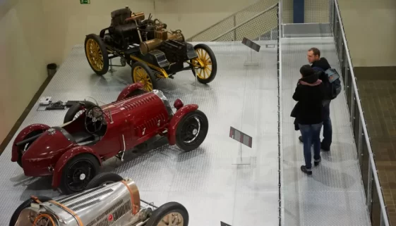 Pár se dívá na vystavené historiecké vozy v muzeu