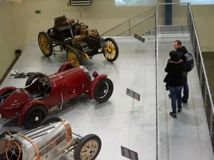 Pár se dívá na vystavené historiecké vozy v muzeu