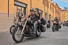 Lidé projíždí ulicí na motorkách