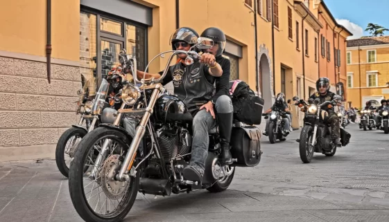 Lidé projíždí ulicí na motorkách