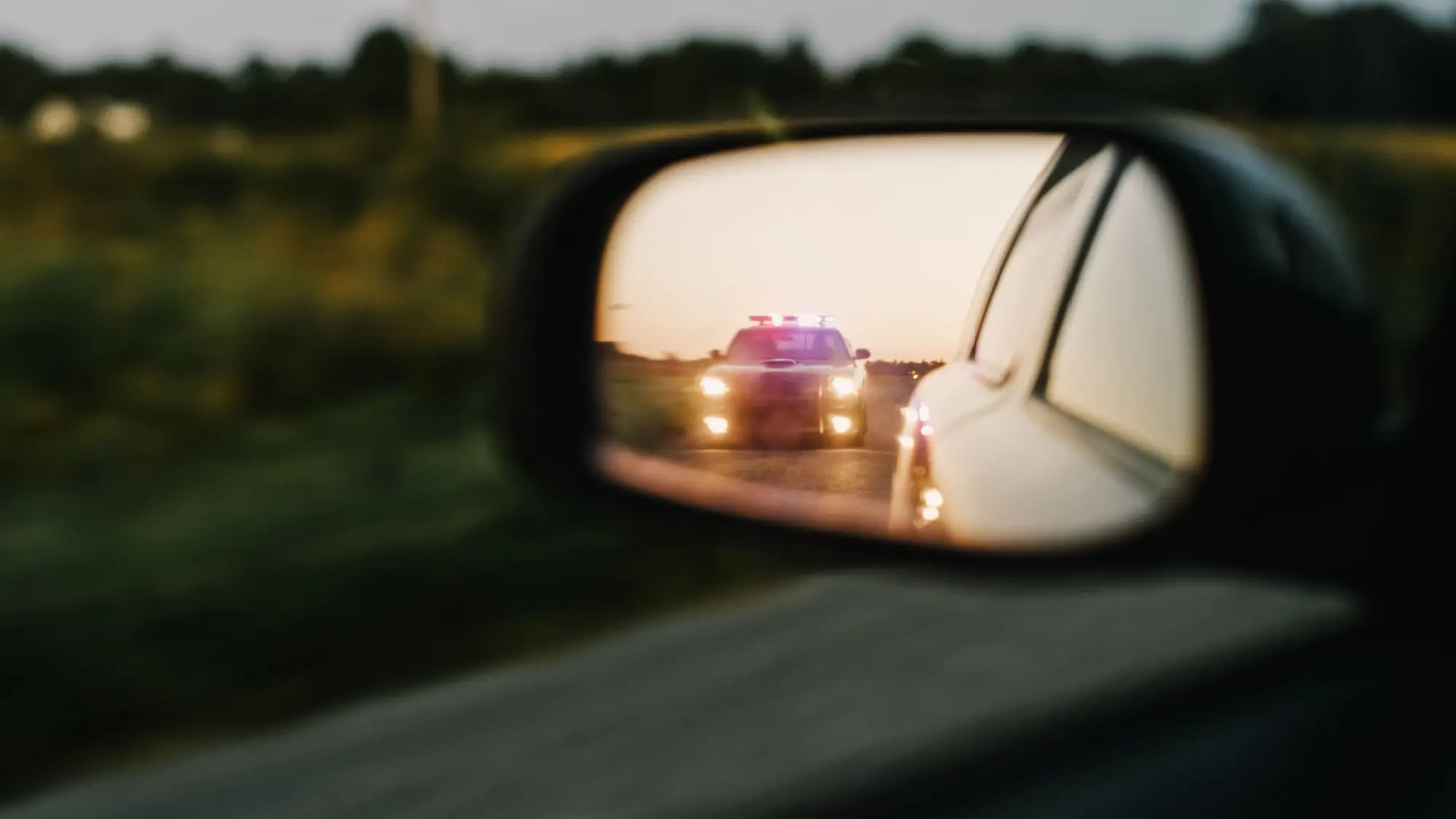 Rychle jedoucí auto ve zpětné zrcátku.