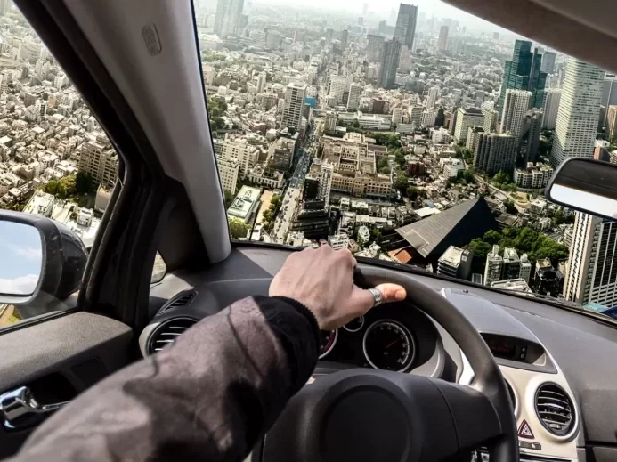 Auto letí nad městem, pohled z perspektivy řidiče