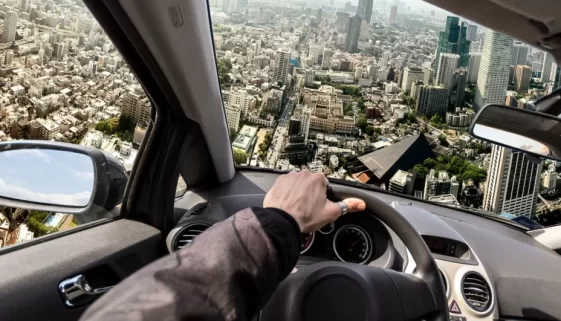 Auto letí nad městem, pohled z perspektivy řidiče