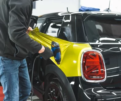 Muž dává na auto fólii