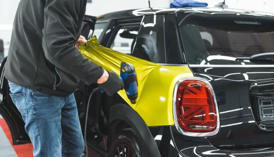 Muž dává na auto fólii