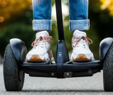 Pohled zblízka na boty jezdce stojícího na Segwayi při jízdě po asfaltu
