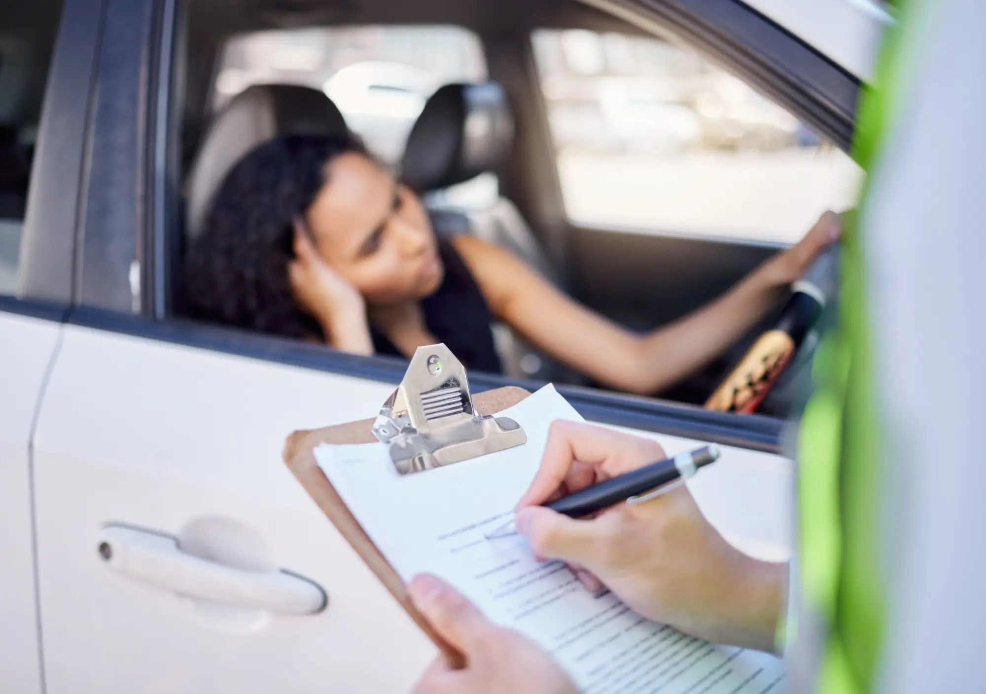 - MotorGuru.cz Znepokojená mladá žena dostávající pokutu.