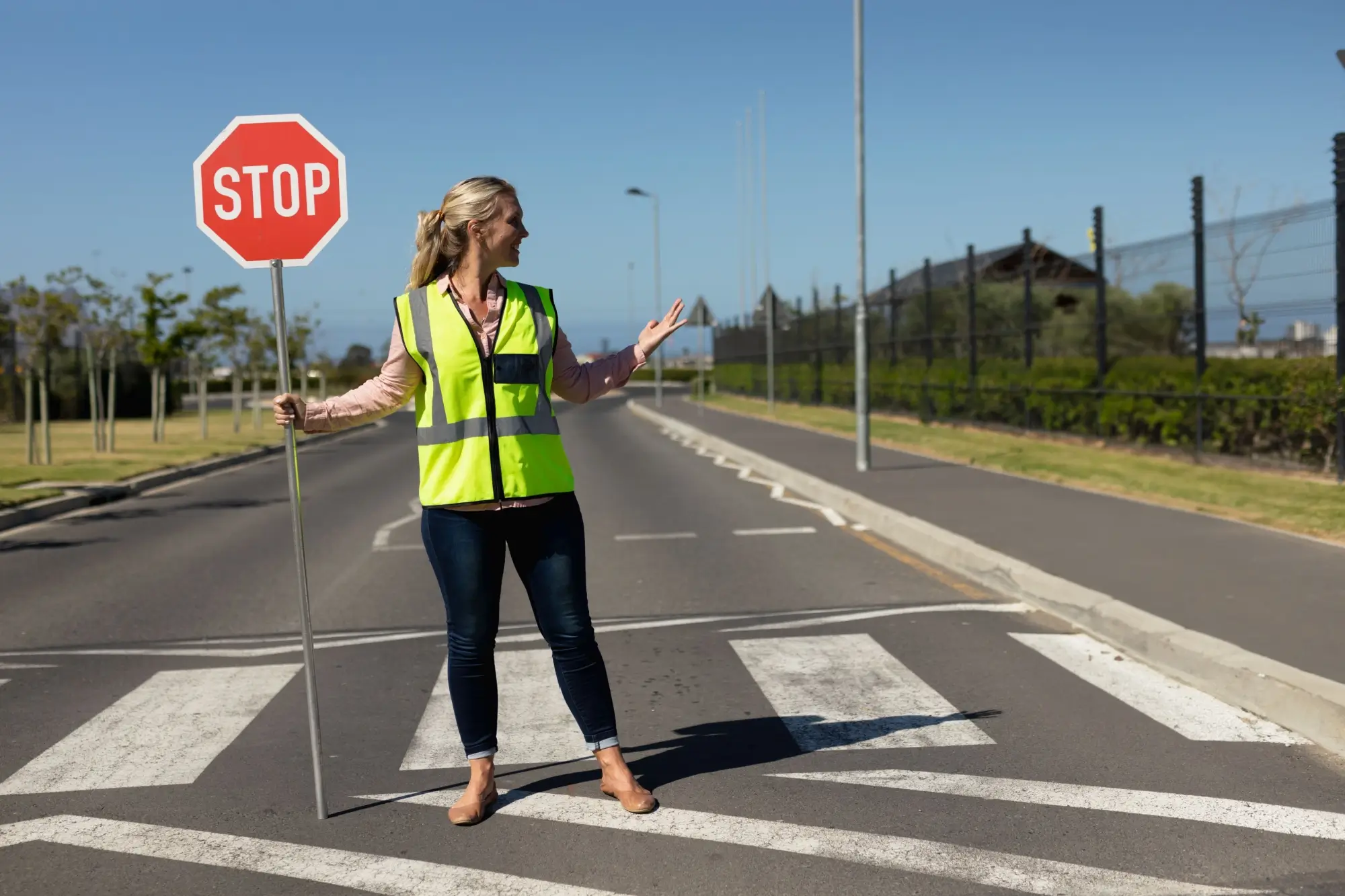 - MotorGuru.cz Mladá žena držící značku STOP na přechodu pro chodce.