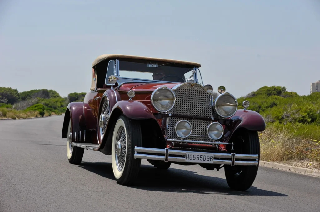 Vínový Packard jede po silnici