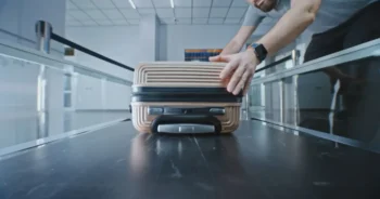 Začátek cesty zavazadla v zákulisí letiště, kde se kufr vydává do automatizovaného systému třídění a přepravy.
