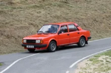 Červená Škoda 120 jedoucí po klikaté silnici.