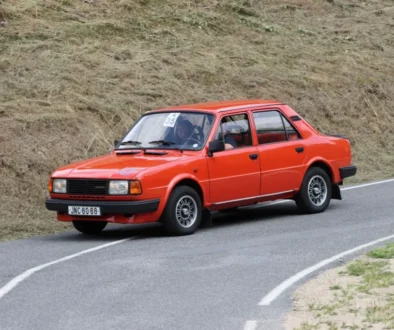 Červená Škoda 120 jedoucí po klikaté silnici.