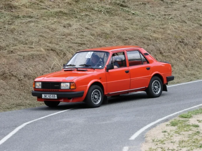 Červená Škoda 120 jedoucí po klikaté silnici.