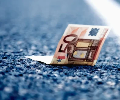 Detail padesátieurové bankovky ležící na asfaltu dálnice