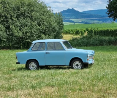 Světle modrý Trabant zaparkovaný na louce