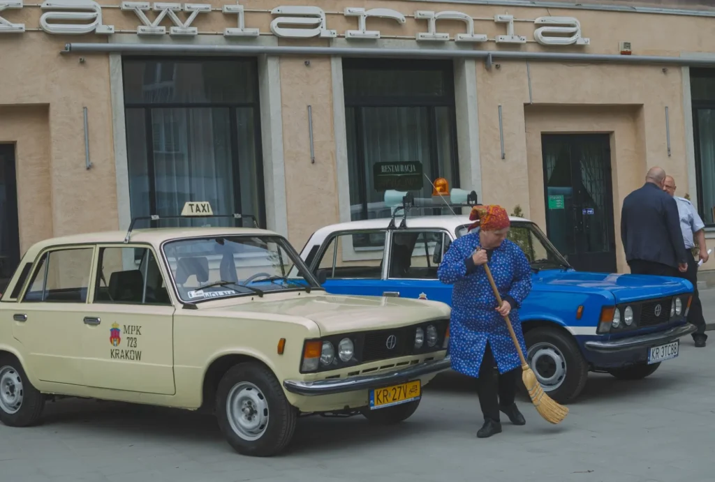 Dvě klasická auta značky Fiat 125p, jedno v barvách historického krakovského taxi a druhé v policejním provedení.