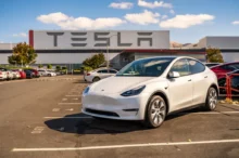 Bílá Tesla na parkovišti před firmou Tesla