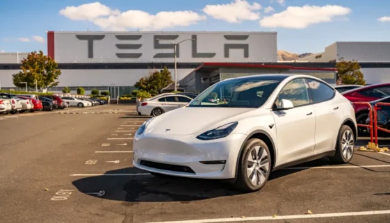 Bílá Tesla na parkovišti před firmou Tesla
