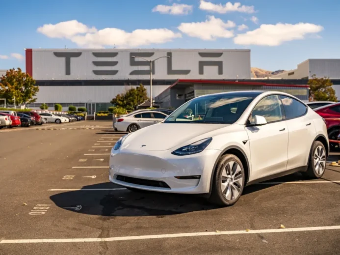 Bílá Tesla na parkovišti před firmou Tesla