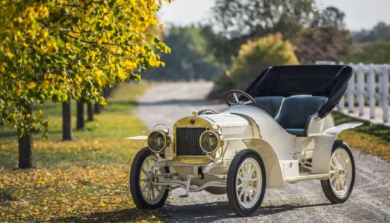 Automobil Laurin & Klement BSC z roku 1908 zaparkovaný na cestě lemované stromy