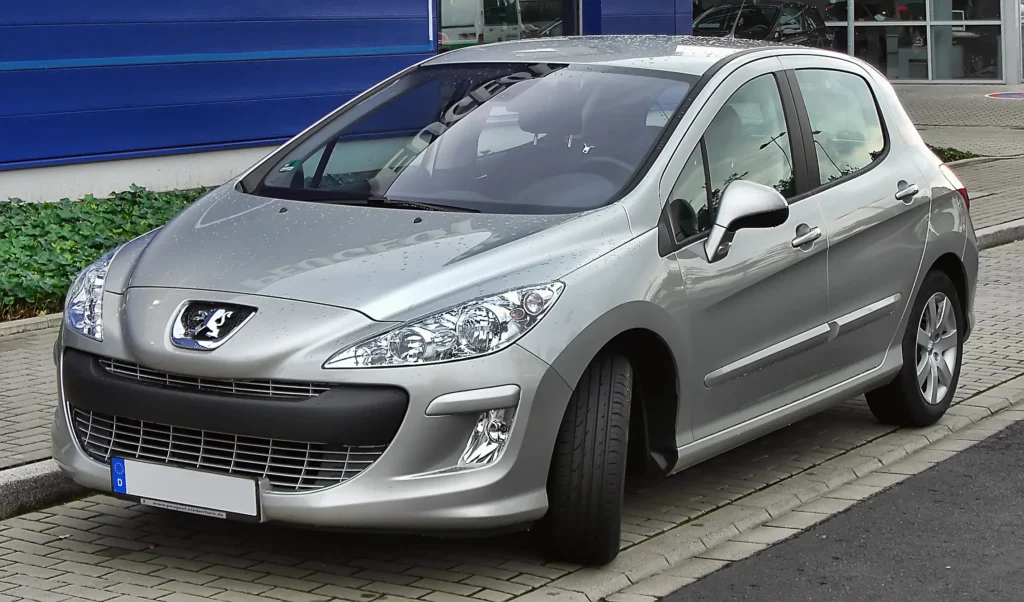 - MotorGuru.cz Stříbrný Peugeot 308 zaparkovaný před budovou