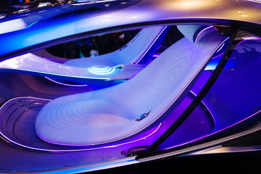 Shutterstock_2065158167 - MotorGuru.cz Detail futuristického interiéru vozu Mercedes-Benz VISION AVTR s plynulými tvary sedadel, fialovým a modrým ambientním osvětlením a minimalistickým designem bez volantu