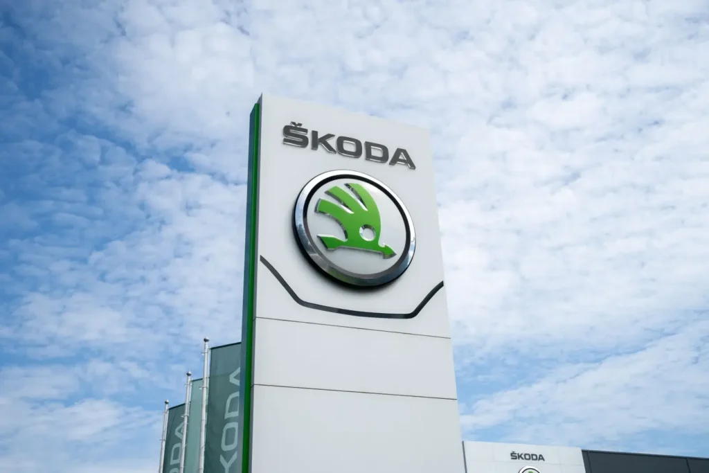 Logo automobilky Škoda na sloupu před showroomem