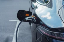 Záběr na elektromobil připojený k nabíjecí stanici