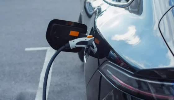 Záběr na elektromobil připojený k nabíjecí stanici