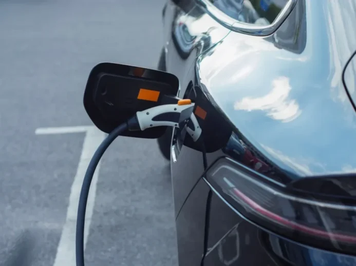 Záběr na elektromobil připojený k nabíjecí stanici