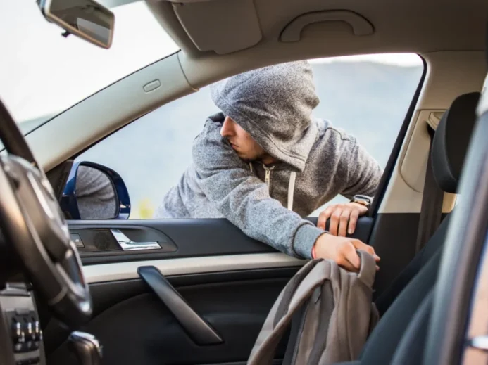 Muž vytahuje batoh z auta