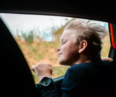 dítě vykukující z okna auta