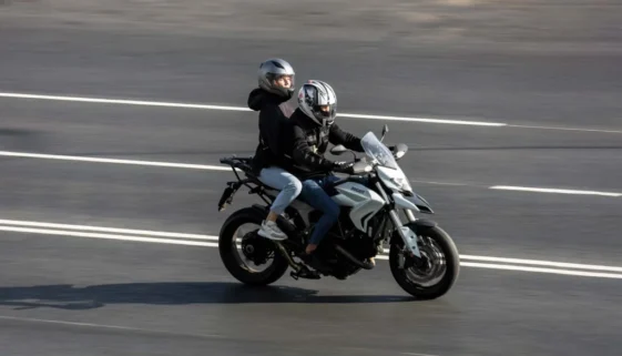 Dva lidé jedoucí na motorce