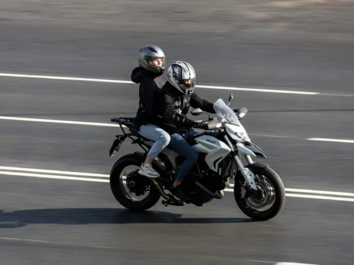 Dva lidé jedoucí na motorce