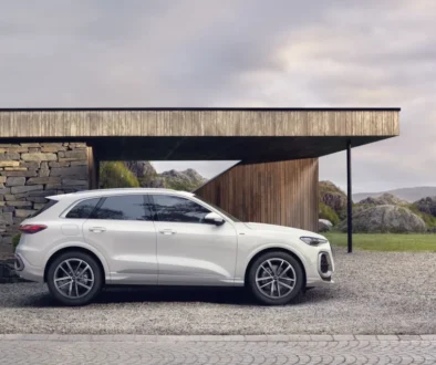 Bílá Audi Q5 zaparkovaná před moderním domem v horské krajině